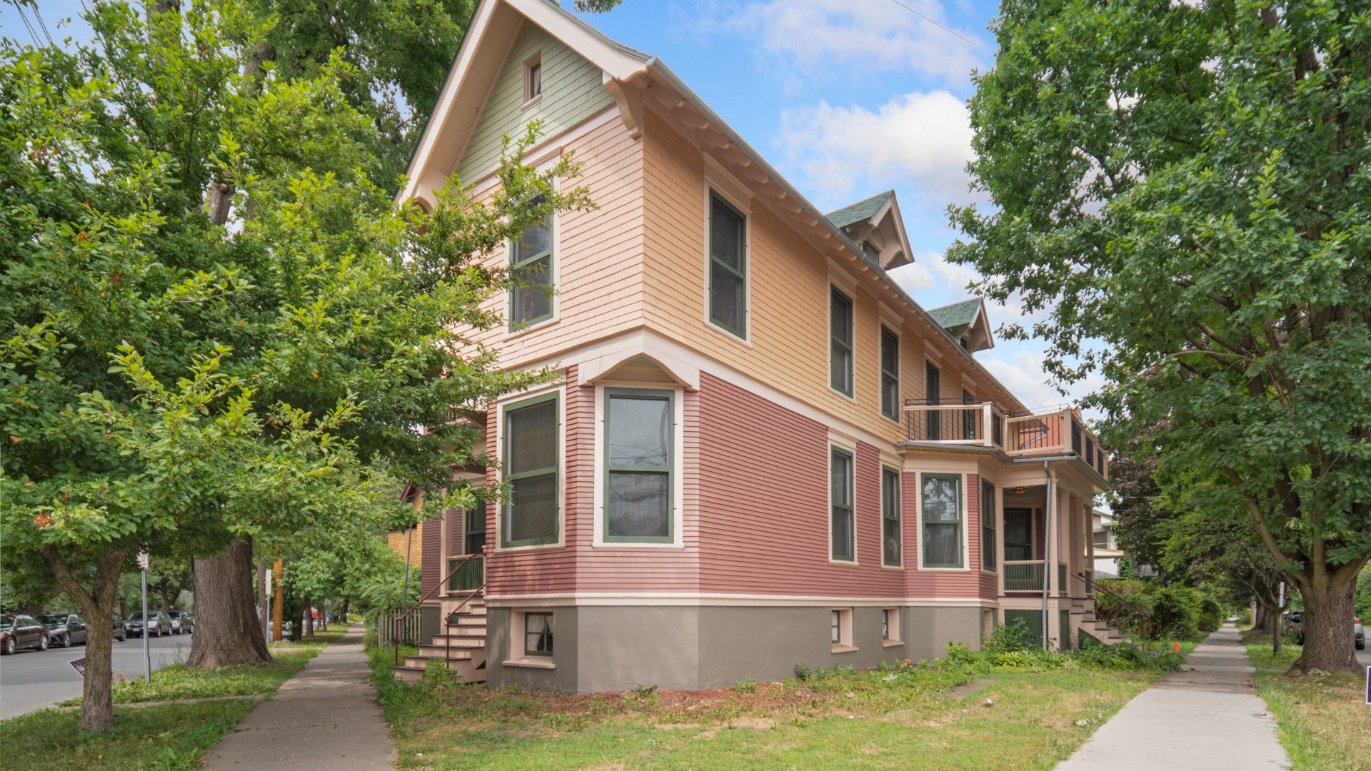 Exterior view of 104 Lake Avenue Ithaca (Cascadilla Corner) Victorian co-op home, painted in shades of pink.